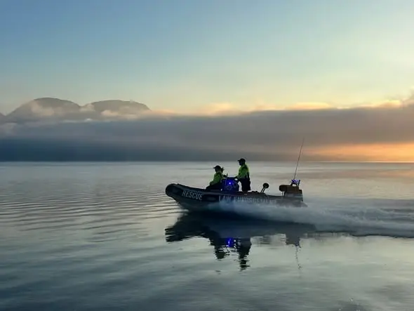 A rescue boat crossing the dam at first light
